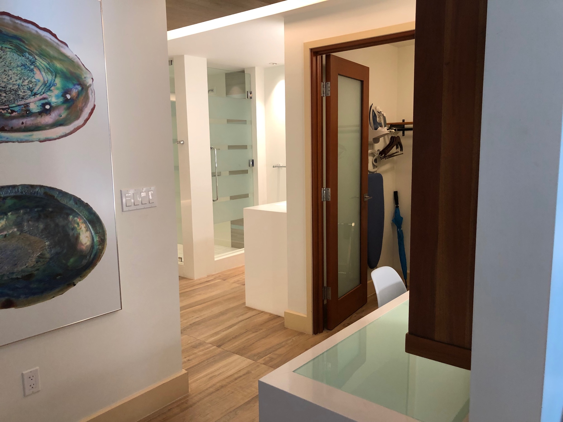 A resort suite dressing area with a walk-in closet and shell artwork