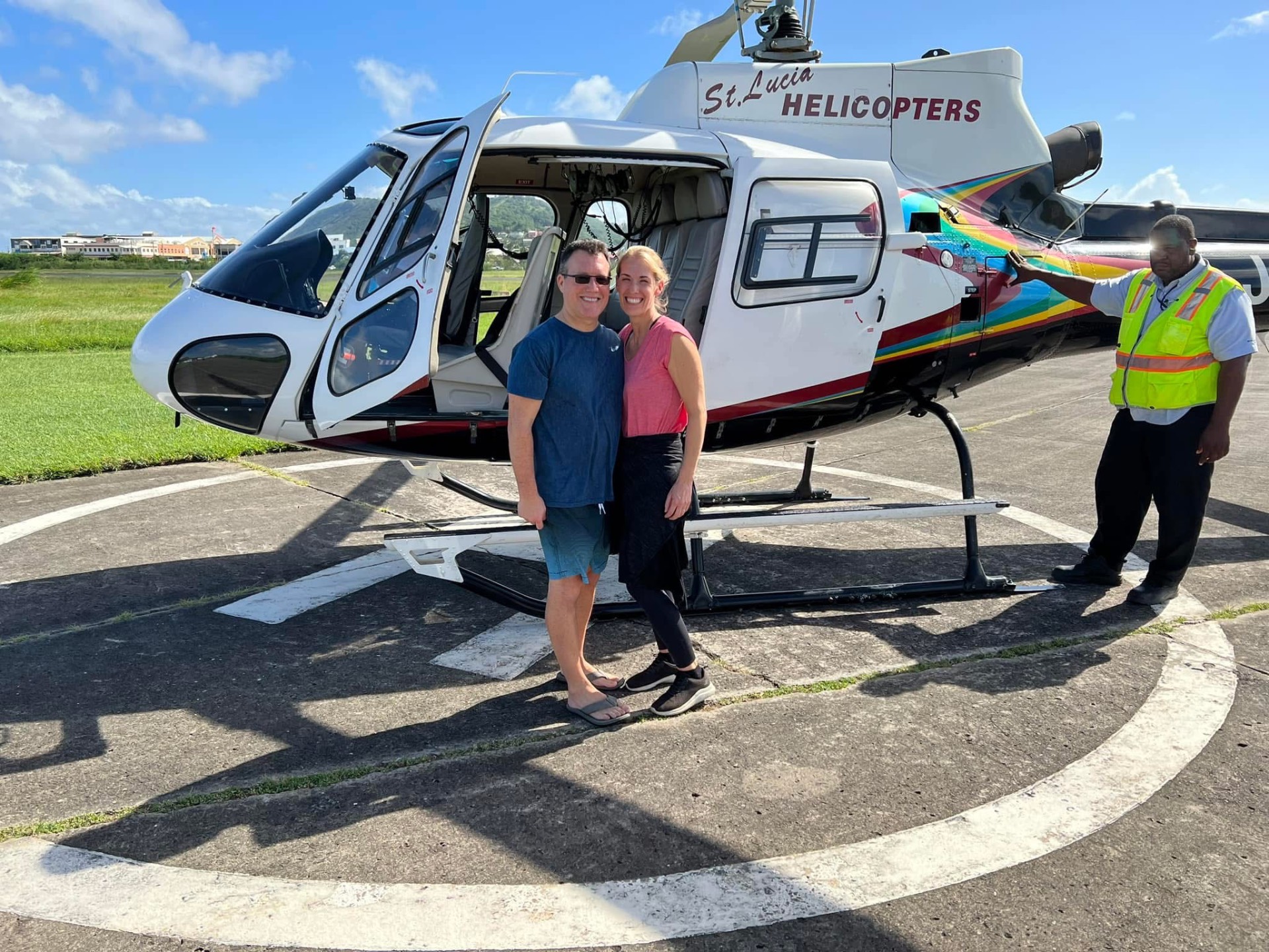 Adam and Jen Conway in front of a St. Lucia Helicopters aircraft on the tarmac