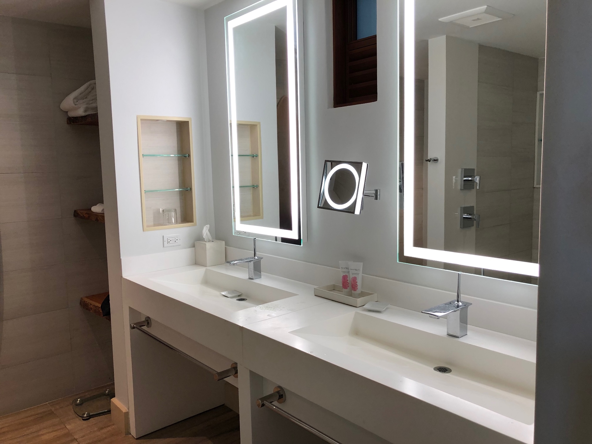 A resort suite double vanity with backlit mirrors and chrome fixtures